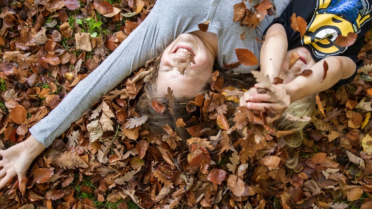 Children playing the the autumn leaves